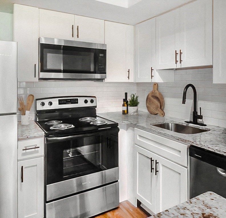 a white kitchen with stainless steel appliances and white cabinets
