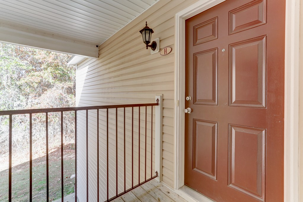 A brown door is on the right side of a white wall.