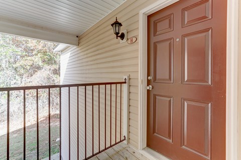 A brown door is on the right side of a white wall.