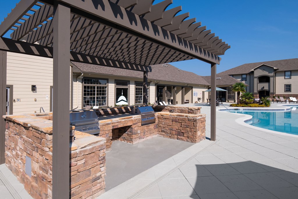 a patio with a bar and a pool in front of a house