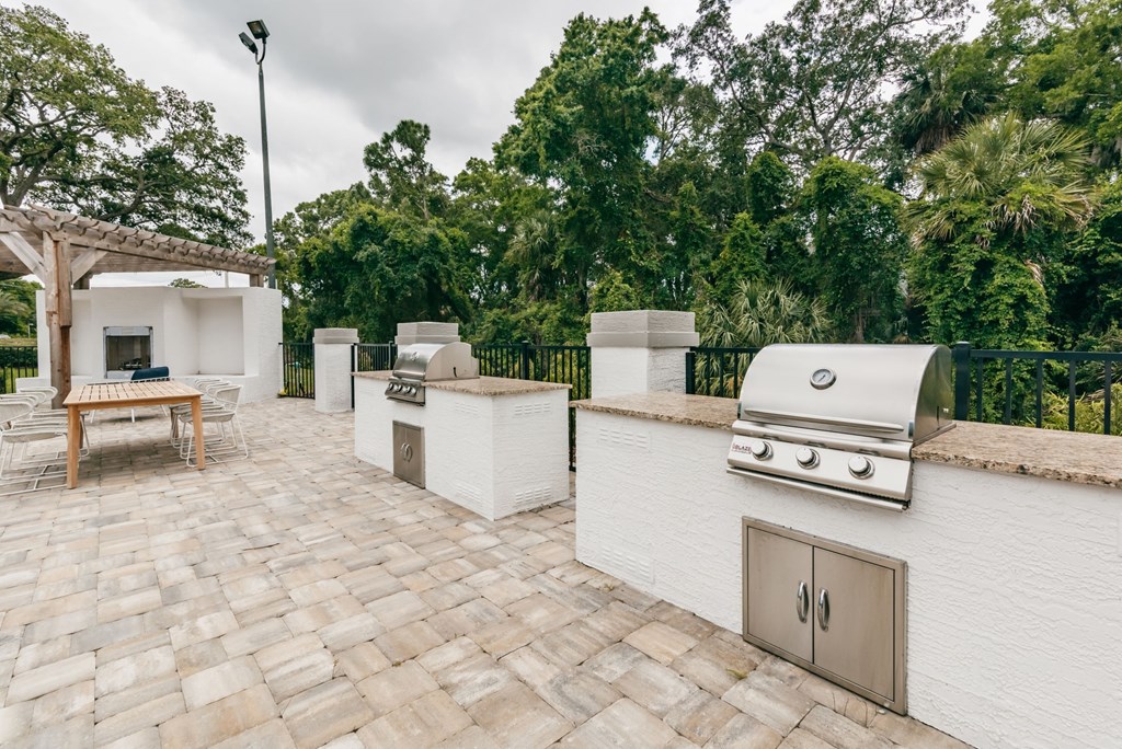 a patio with a barbecue grill and a table