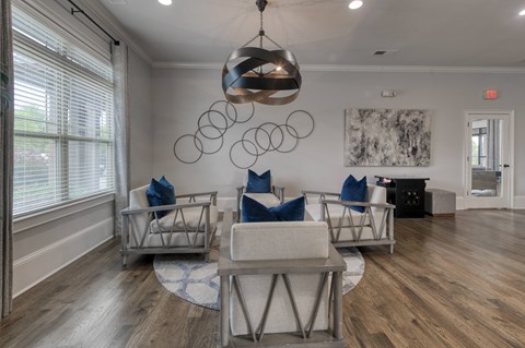 A modern living room with a large chandelier and a painting on the wall.
