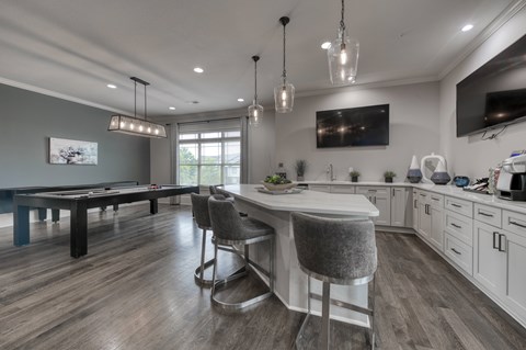 A modern kitchen with a dining table and bar stools.
