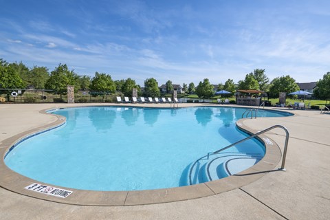 A large outdoor swimming pool with a metal railing around it.