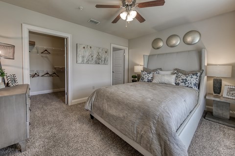 A bedroom with a large bed and a ceiling fan.