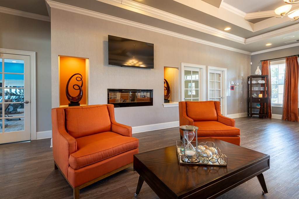 a living room with orange chairs and a coffee table