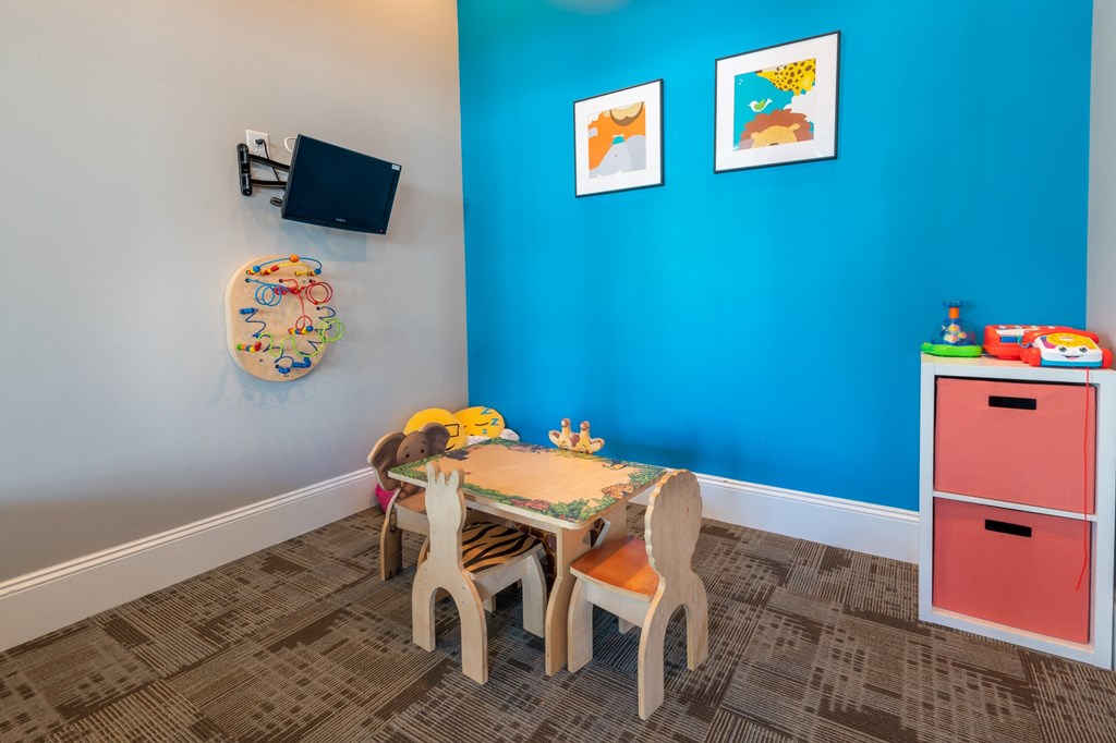 a play room with a table and chairs and a television
