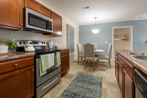 full kitchen with stainless steel appliances and a dining room with a table and chairs