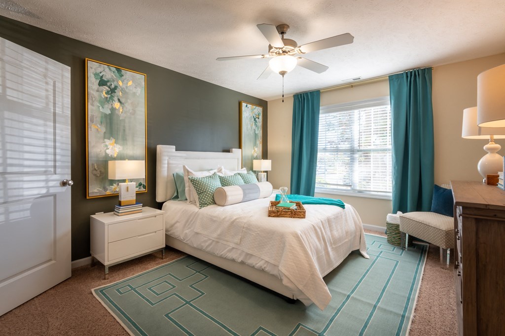 a bedroom with a bed and a ceiling fan