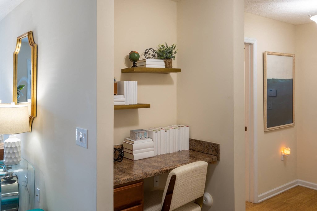 a room with a desk and a chair and a mirror