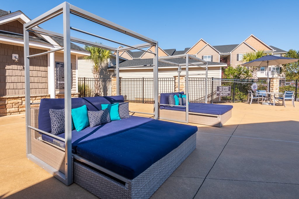 an outdoor patio with couches and a table and chairs