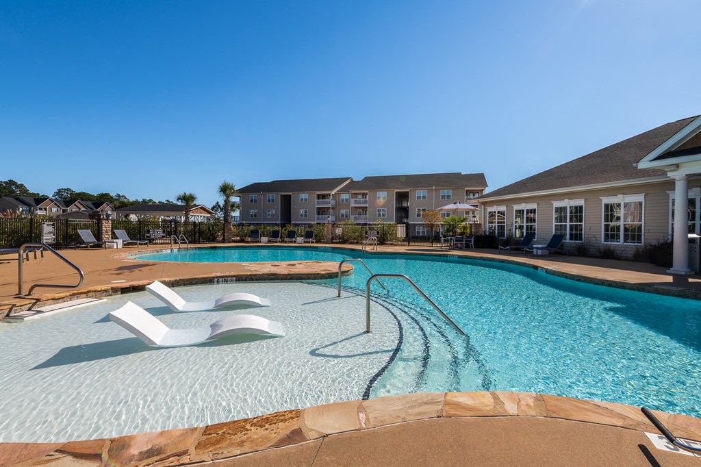 a large swimming pool with a building in the background