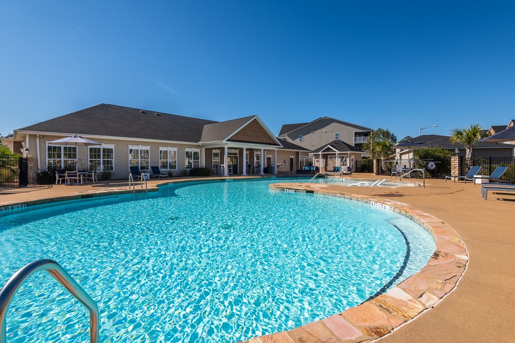 a large swimming pool with a house in the background