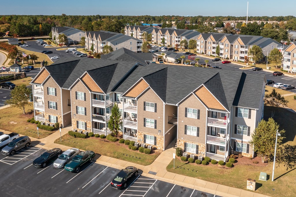 an aerial view of an apartment complex with cars parked in a parking lot
