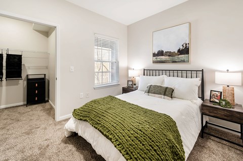 A bedroom with a large bed and a painting on the wall.