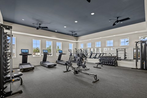 A spacious gym with treadmills, elliptical machines, and other exercise equipment.
