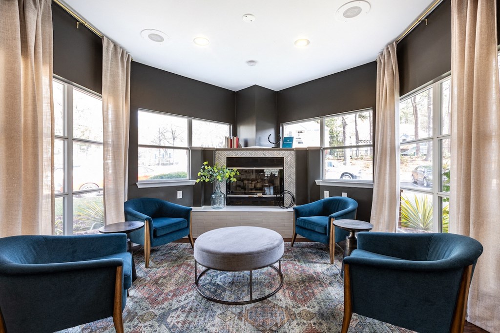 a living room with blue chairs and a fireplace