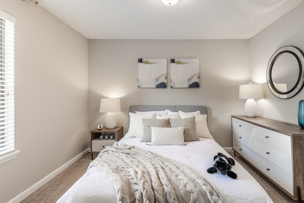 a bedroom with a bed and a dresser and a mirror