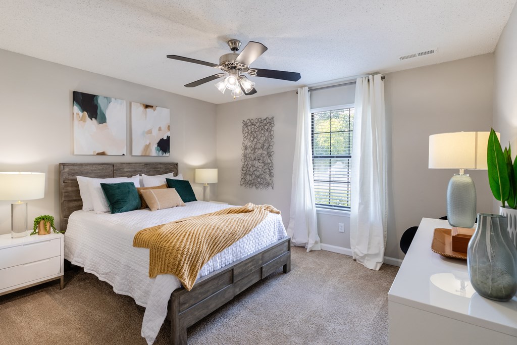 a bedroom with a large bed and a ceiling fan
