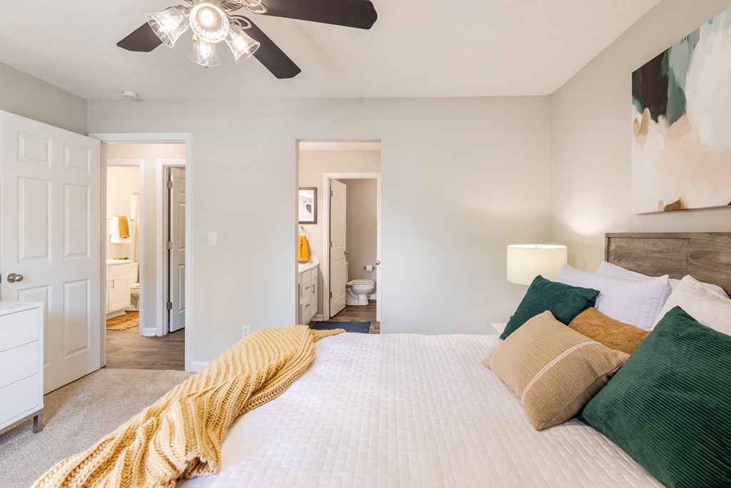 a bedroom with a large bed and a ceiling fan