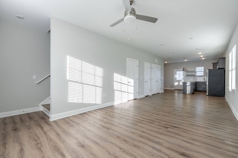 a living room with white walls and a ceiling fan