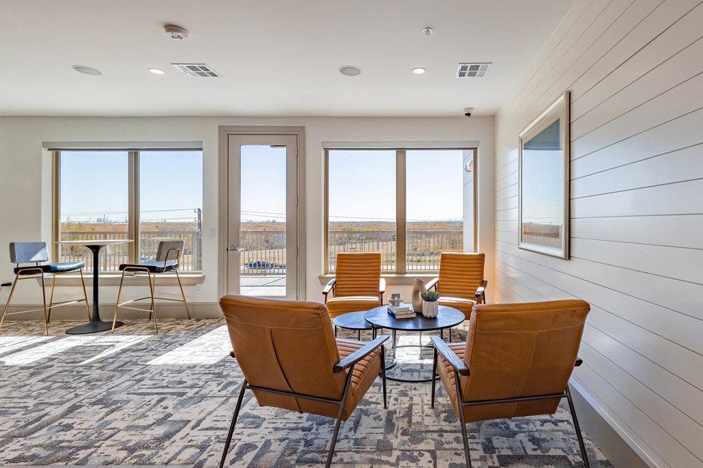 A room with a table and chairs and a view of the outside.
