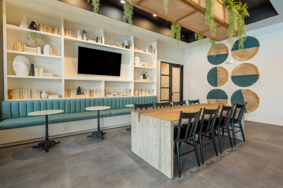 a dining room with a long table and chairs and a tv