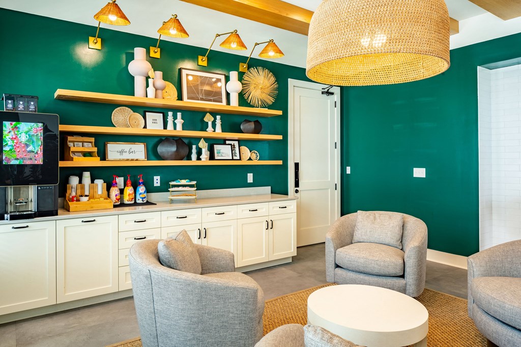 a living room with chairs and a coffee table and a green wall with a television
