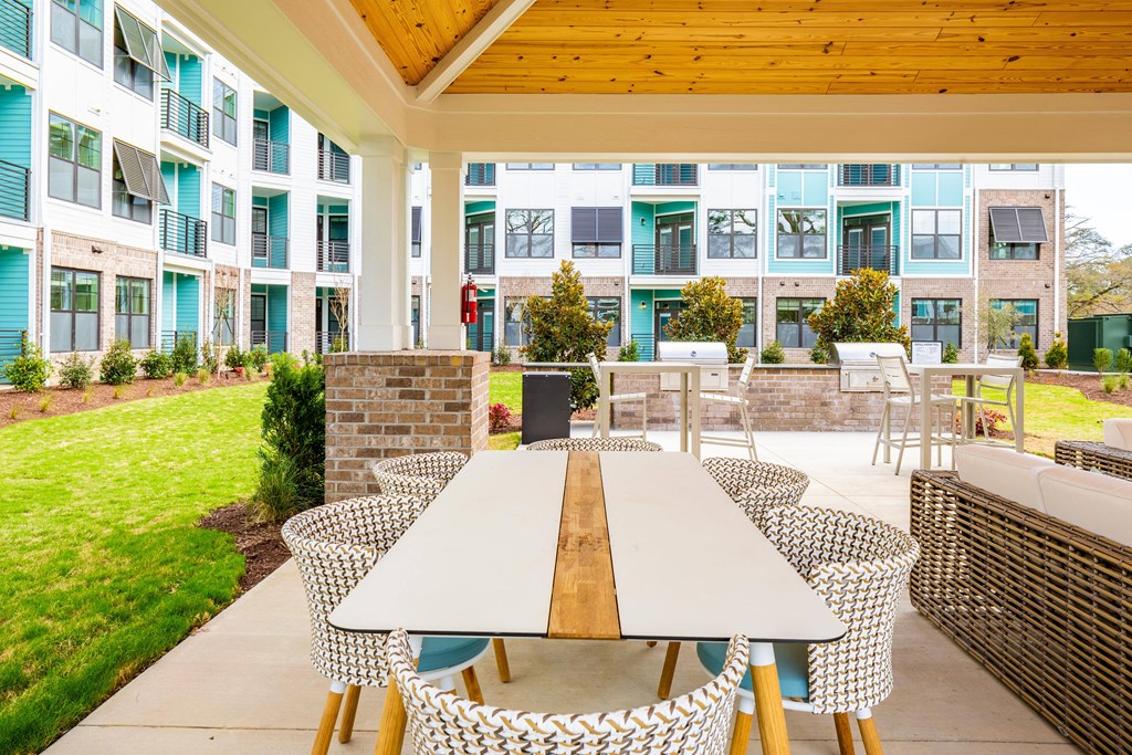 an outdoor patio with a table and chairs in front of an apartment building