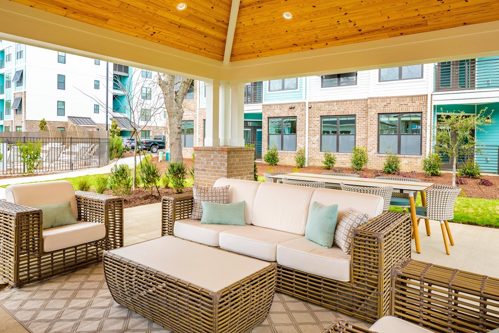 a covered patio with wicker furniture and a wooden ceiling