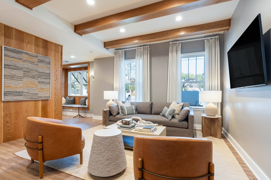 a living room with a couch and chairs and a tv