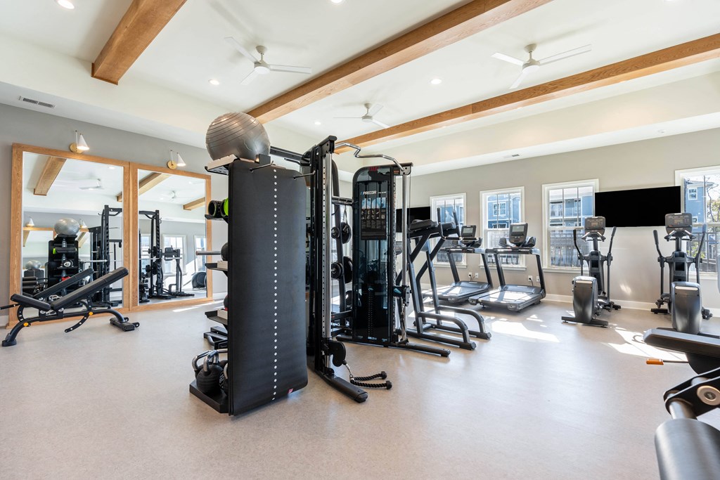 a gym with cardio equipment and weights on the floor