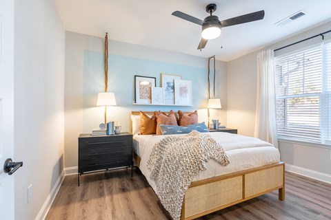 A bedroom with a bed, nightstands, and a ceiling fan.