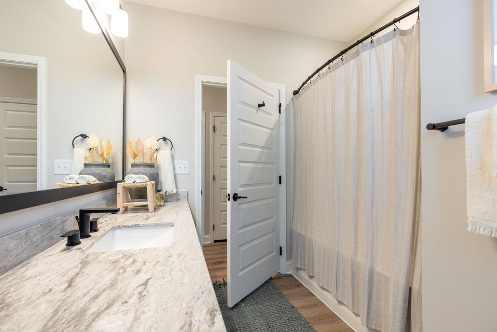 a bathroom with a shower and a sink and a mirror