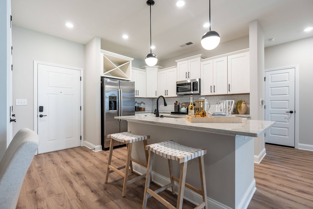 a kitchen with a large island with two stools