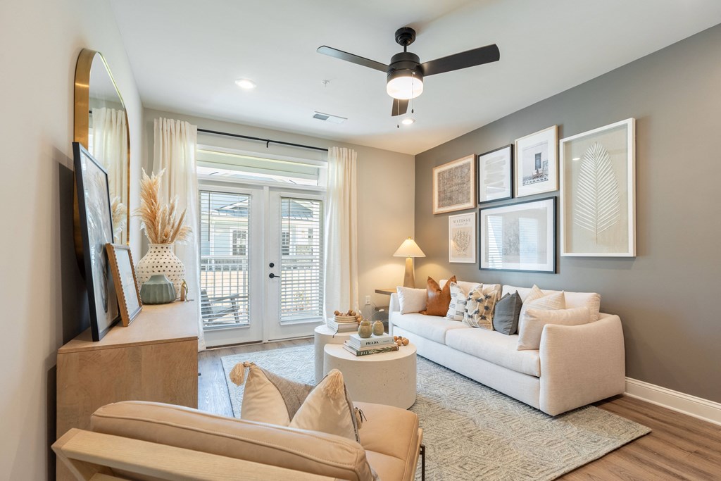 a living room with a white couch and a ceiling fan