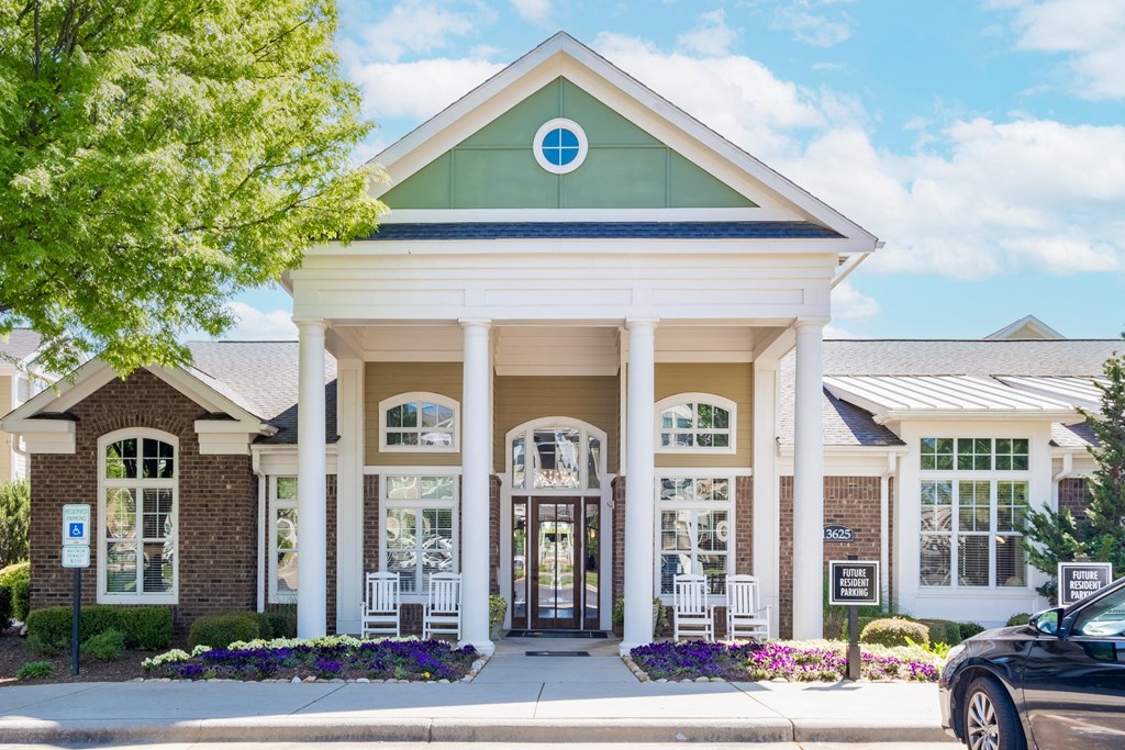 a large building with a porch and a car parked in front of it