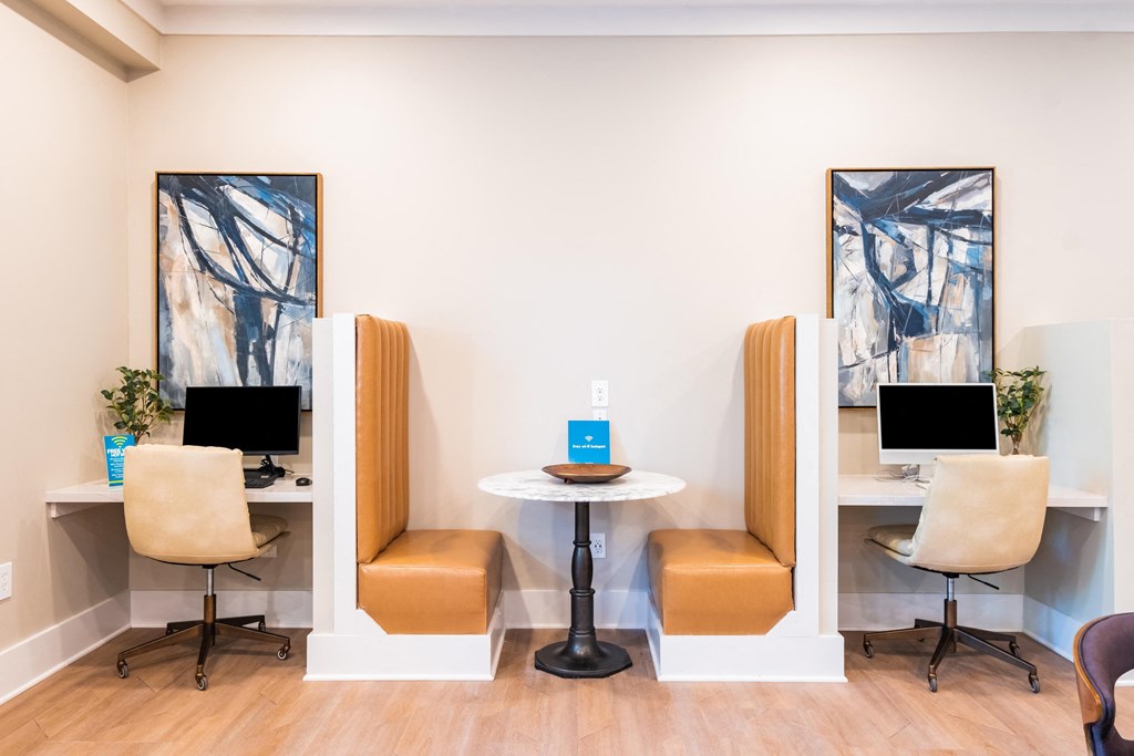 two chairs and a table in front of two computer monitors