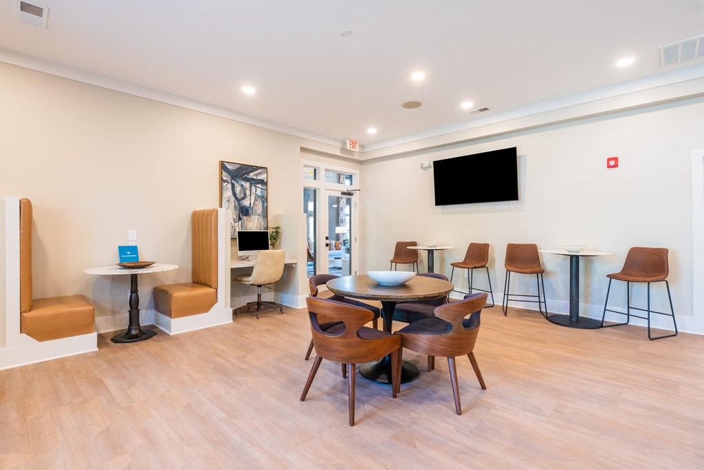a room with a table and chairs and a tv on the wall