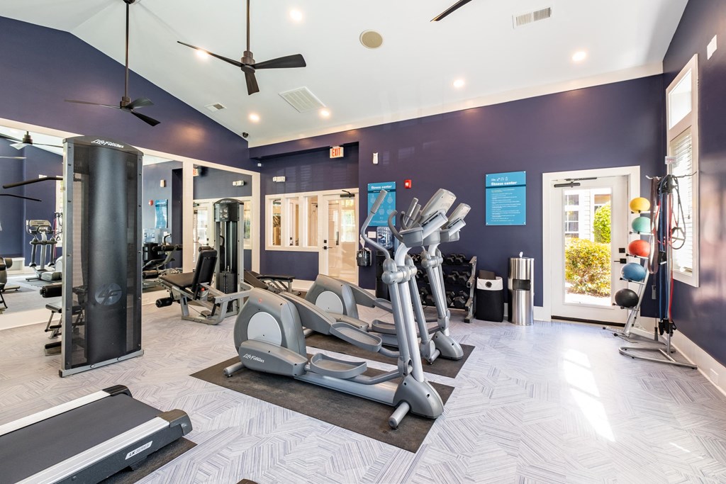 a gym with cardio equipment and weights at the enclave at woodbridge apartments in sugar land,