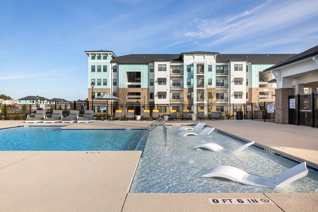 a swimming pool with an apartment building in the background