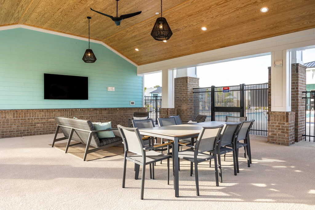 a patio with a table and chairs and a tv
