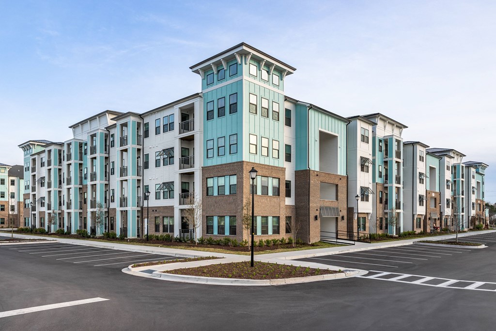 an exterior view of an apartment building with a parking lot