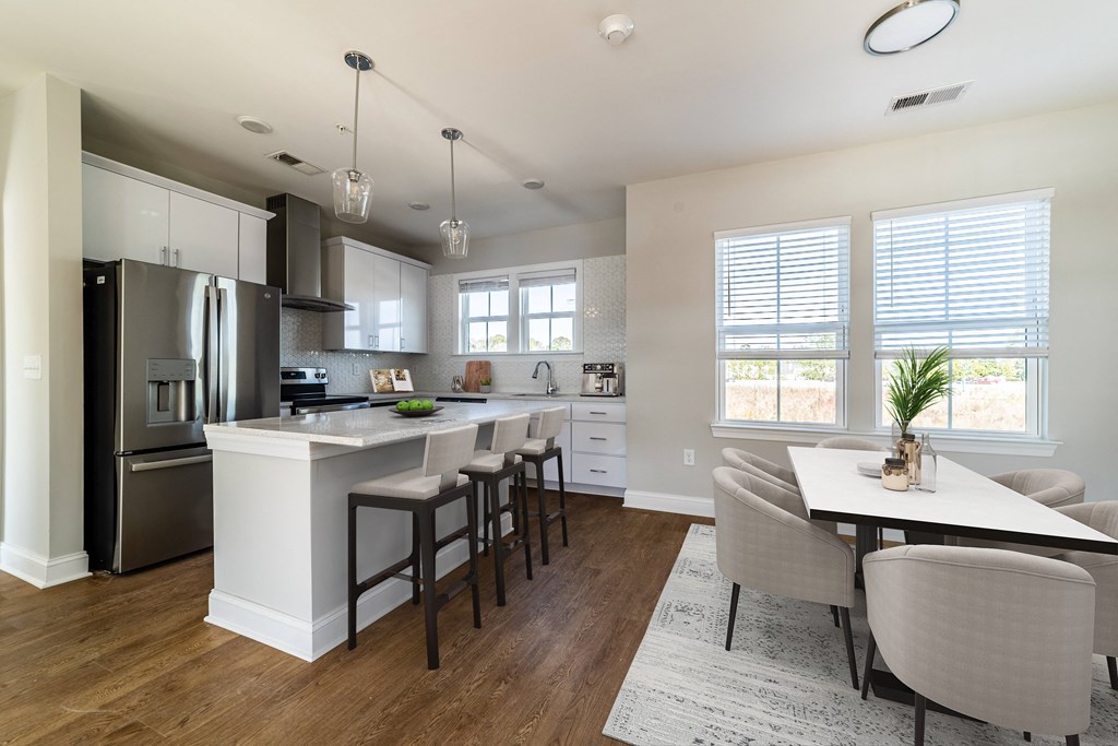 a kitchen with a large island and a table with chairs