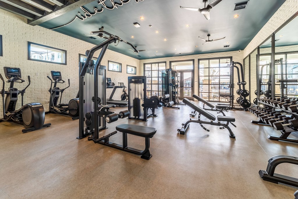 a gym with weights and other exercise equipment and windows