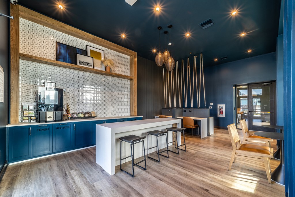 a kitchen with blue cabinets and a bar with stools
