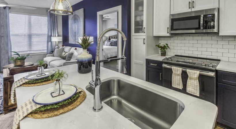 a kitchen with a sink and a counter top and a microwave