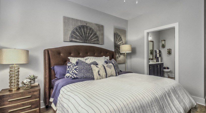 a bedroom with a large bed and a door to a bathroom