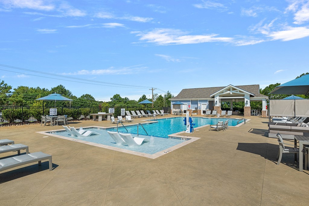 a large pool with lounge chairs and umbrellas