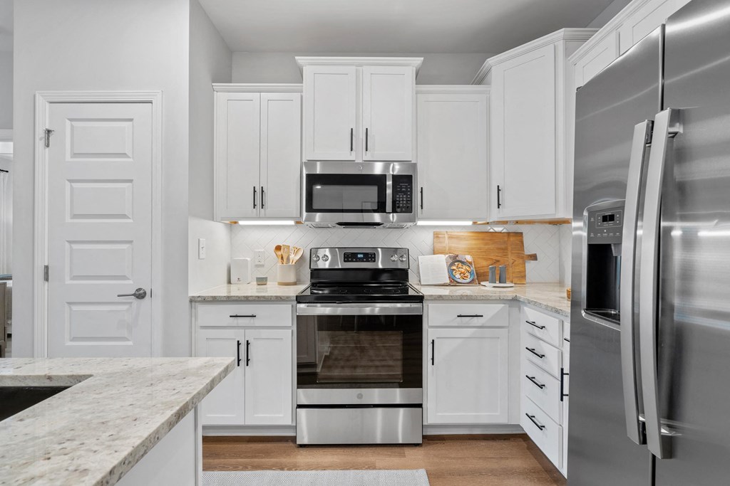 a kitchen with white cabinets and stainless steel appliances